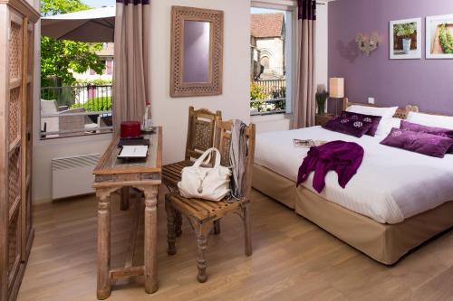 Logis hotel les flots bleus في بوليو سور دوردوني: غرفة نوم بسرير وطاولة ومكتب