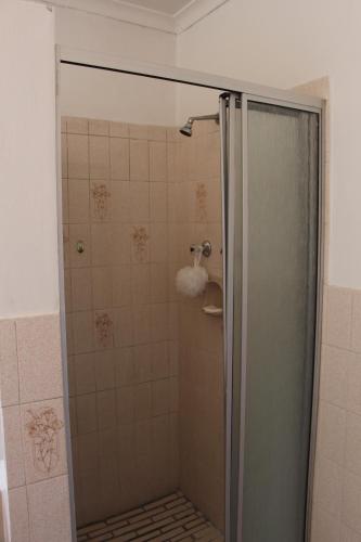 a shower with a glass door in a bathroom at Turning Point Bed & Breakfast in Cape Town