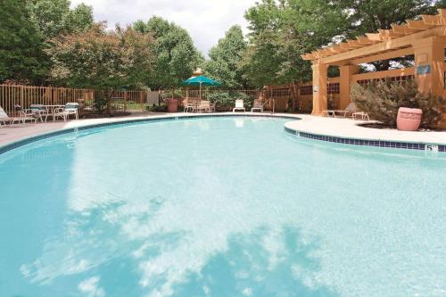 einen großen Pool mit einer hölzernen Pergola in der Unterkunft La Quinta by Wyndham Colorado Springs South Airport in Colorado Springs