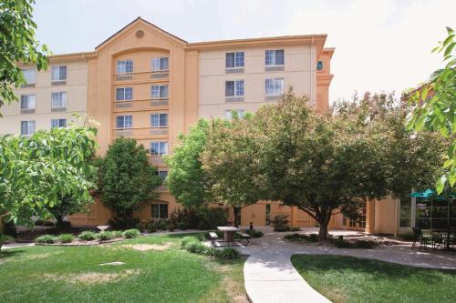 a building with trees and a park in front of it at La Quinta by Wyndham Colorado Springs South Airport in Colorado Springs