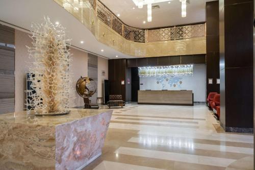 a lobby of a hotel with a table in the middle at Clarion Hotel Istanbul Mahmutbey in Istanbul