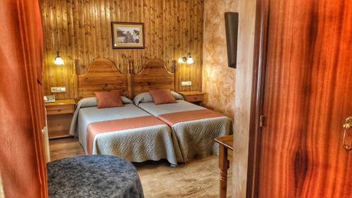 1 dormitorio con 1 cama en una habitación con paredes de madera en Sorrosal, en Broto