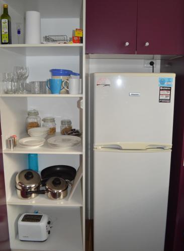 um frigorífico branco com a porta aberta numa cozinha em Waterfall Cottage em Rosebud