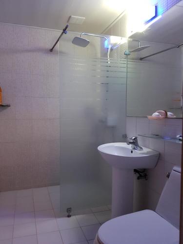 y baño con lavabo, aseo y ducha. en Plus Motel en Gwangju