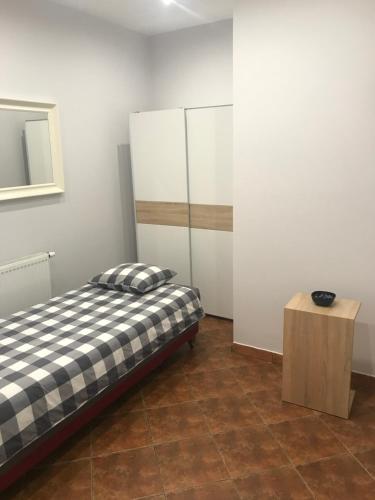 1 dormitorio con cama y mesa de madera en Piwnica, en Miechów