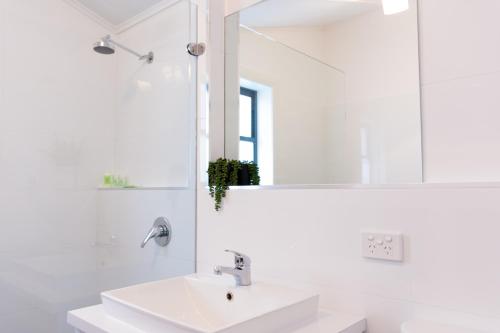 a white bathroom with a sink and a mirror at Agnes Cottage Bed & Breakfast in Kingston South East