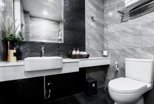 a bathroom with a white toilet and a sink at แจสเปอร์โฮเทล Jasper Hotel in Ban Phai