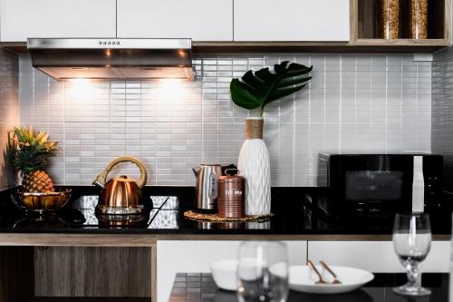 a kitchen with a black counter top with wine glasses at แจสเปอร์โฮเทล Jasper Hotel in Ban Phai