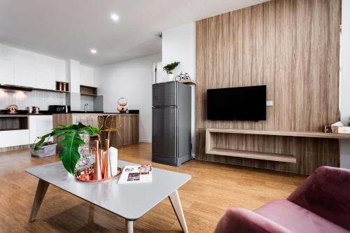 a living room with a white table and a refrigerator at แจสเปอร์โฮเทล Jasper Hotel in Ban Phai