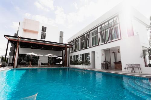 a swimming pool in front of a building at แจสเปอร์โฮเทล Jasper Hotel in Ban Phai