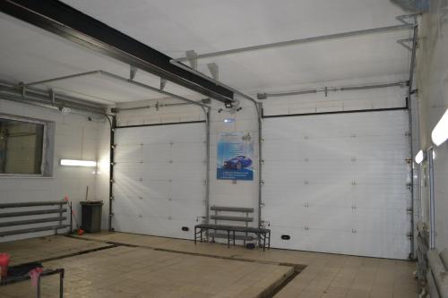 a garage with two doors with a bench in it at Ayhan Hotel in Aktobe