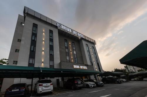 a building with cars parked in a parking lot at Brown-Dot Hotel Dongchon Amusement Park in Daegu