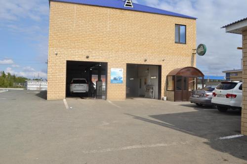 a garage with cars parked in a parking lot at Ayhan Hotel in Aktobe