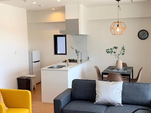 a living room and kitchen with a couch and a table at European House Reisen in Fukuoka