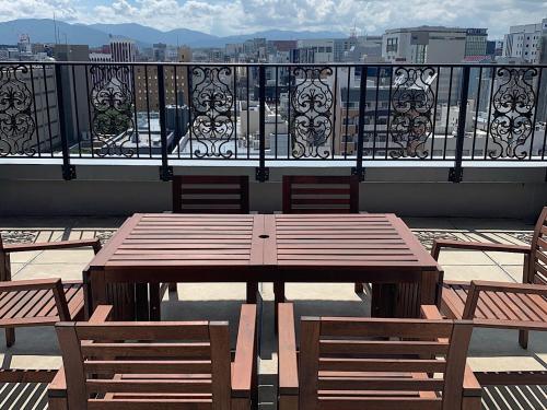 a wooden table and chairs on a balcony at European House Reisen in Fukuoka