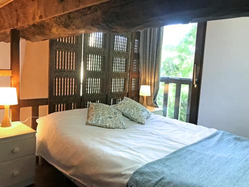 um quarto com uma cama com duas almofadas e uma janela em Hameau de Montcabirol - Pyrénées em Mirepoix