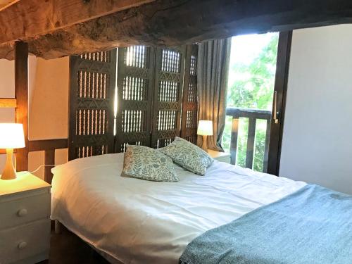 a bedroom with a bed with two pillows and a window at Hameau de Montcabirol - Pyrénées in Mirepoix