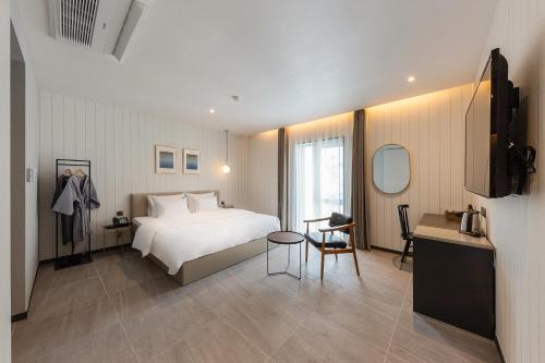 a bedroom with a bed and a table and a desk at Brown-Dot Hotel Dongchon Amusement Park in Daegu
