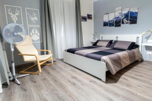 um quarto com uma cama, uma cadeira e uma ventoinha em Le quattro stagioni em Levico Terme