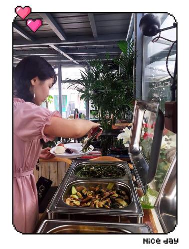 a woman preparing food in a restaurant kitchen at Xi'an Travelling with Hotel South Gate in Xi'an