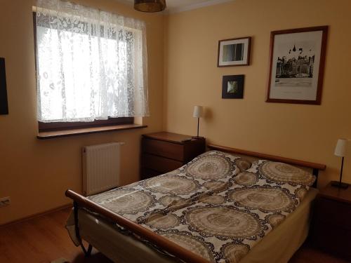 a bedroom with a bed and a window at Wigwam Apartament 6-osobowy in Sopot
