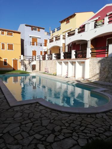 a swimming pool in front of some buildings at Апартаменты с великолепным видом на горы in Viddalba