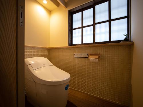 a bathroom with a toilet and a window at 内子の宿 久 in Uchiko