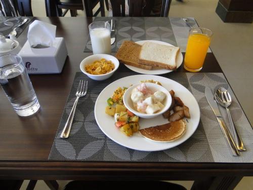 a table with a plate of breakfast food on it at Ganapati Airport Hotel in Kathmandu