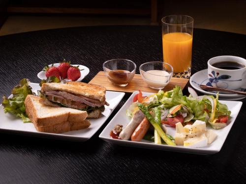 a table with two plates of food with a sandwich and salad at 内子の宿 久 in Uchiko