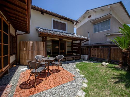 a patio with a table and chairs in front of a house at 内子の宿 久 in Uchiko