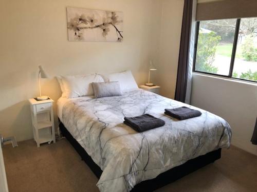 a bedroom with a bed with two towels on it at Willow Dene Holiday Apartments in Bright