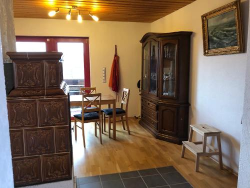 a dining room with a large wooden cabinet and a table at Natürlicher Holzkomfort im hessischen Kegelspiel in Hünfeld