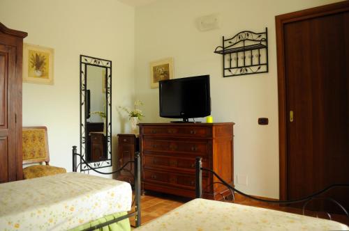 um quarto com uma cama e uma televisão numa cómoda em Tenuta Bellaprima CALTAGIRONE em Niscemi