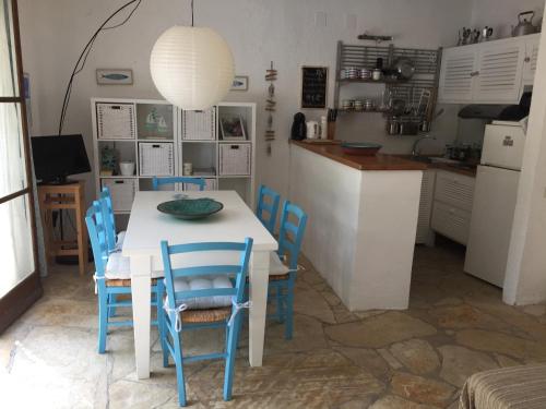 a kitchen with a white table and blue chairs at Alexandra villas in Gouvia
