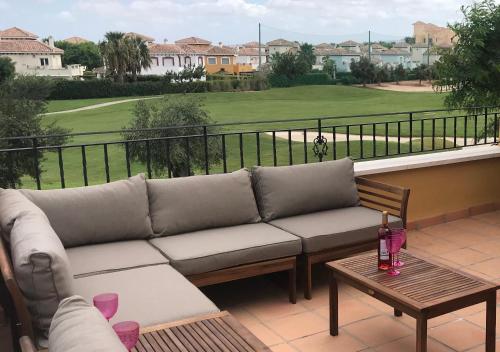 a couch on a balcony with a view of a golf course at Mar Menor Golf Villa - Frontline Detached - Heated Pool in Torre-Pacheco