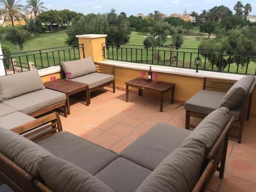 a patio with couches and tables on a balcony at Mar Menor Golf Villa - Frontline Detached - Heated Pool in Torre-Pacheco