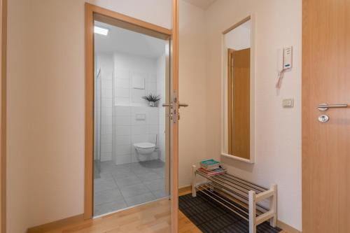 a bathroom with a toilet and a glass door at Perle der Südvorstadt in Leipzig