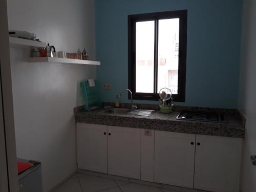 uma cozinha com um lavatório e uma janela em Wind House em Imsouane