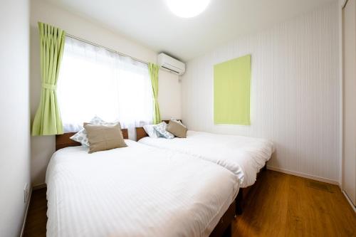 two beds in a small room with a window at ID-STAY Kawaguchiko Ⅱ in Fujikawaguchiko
