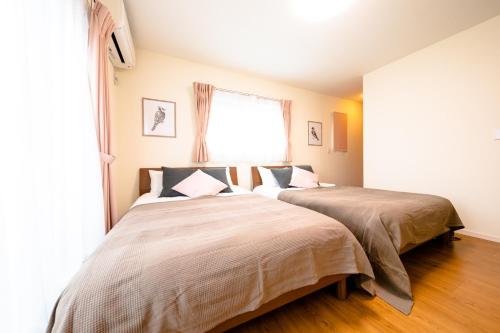two beds sitting next to each other in a bedroom at ID-STAY Kawaguchiko Ⅱ in Fujikawaguchiko