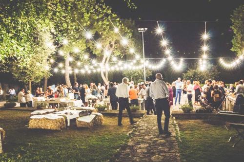 a group of people in a park at night with lights at Relais Masseria Villa Cenci in Cisternino