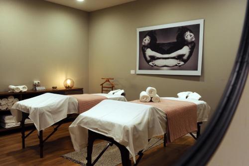 a massage room with two beds and a mirror at Schumacher Hotel Haifa in Haifa