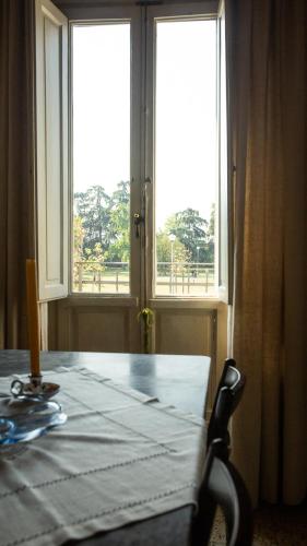 a dining room with a table and two windows at La Casa di Enea in Pistoia