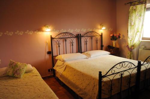 a bedroom with two beds and a window at Tenuta Bellaprima CALTAGIRONE in Niscemi