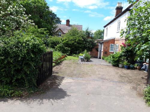 a driveway in front of a house with a fence at rosedale cottage in Walsgrave on Sowe