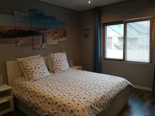 une chambre avec un lit et une fenêtre dans l'établissement Les Agapanthes, à Huisnes-sur-Mer