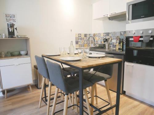 une cuisine avec une table et des chaises dans une cuisine dans l'établissement Appartement écologique - Proche Métro Charpennes, à Villeurbanne