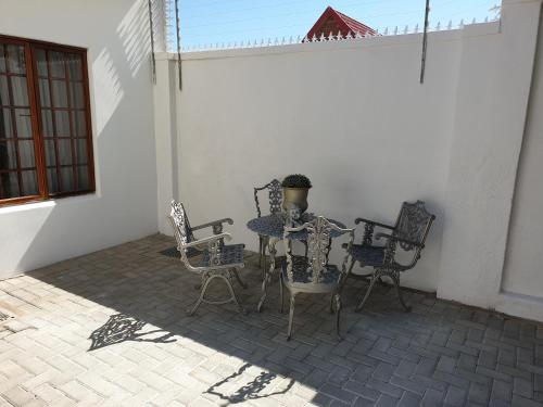 a patio with a table and chairs in a room at Pongola Road Self Catering Accommodation in Uitenhage