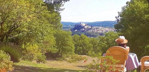 a man sitting on a bench looking at a castle at Le Mas Sérénité in Ansouis