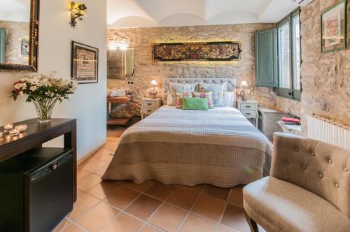 a bedroom with a bed and a chair in a room at El Racó de Madremanya - Adults only in Madremanya